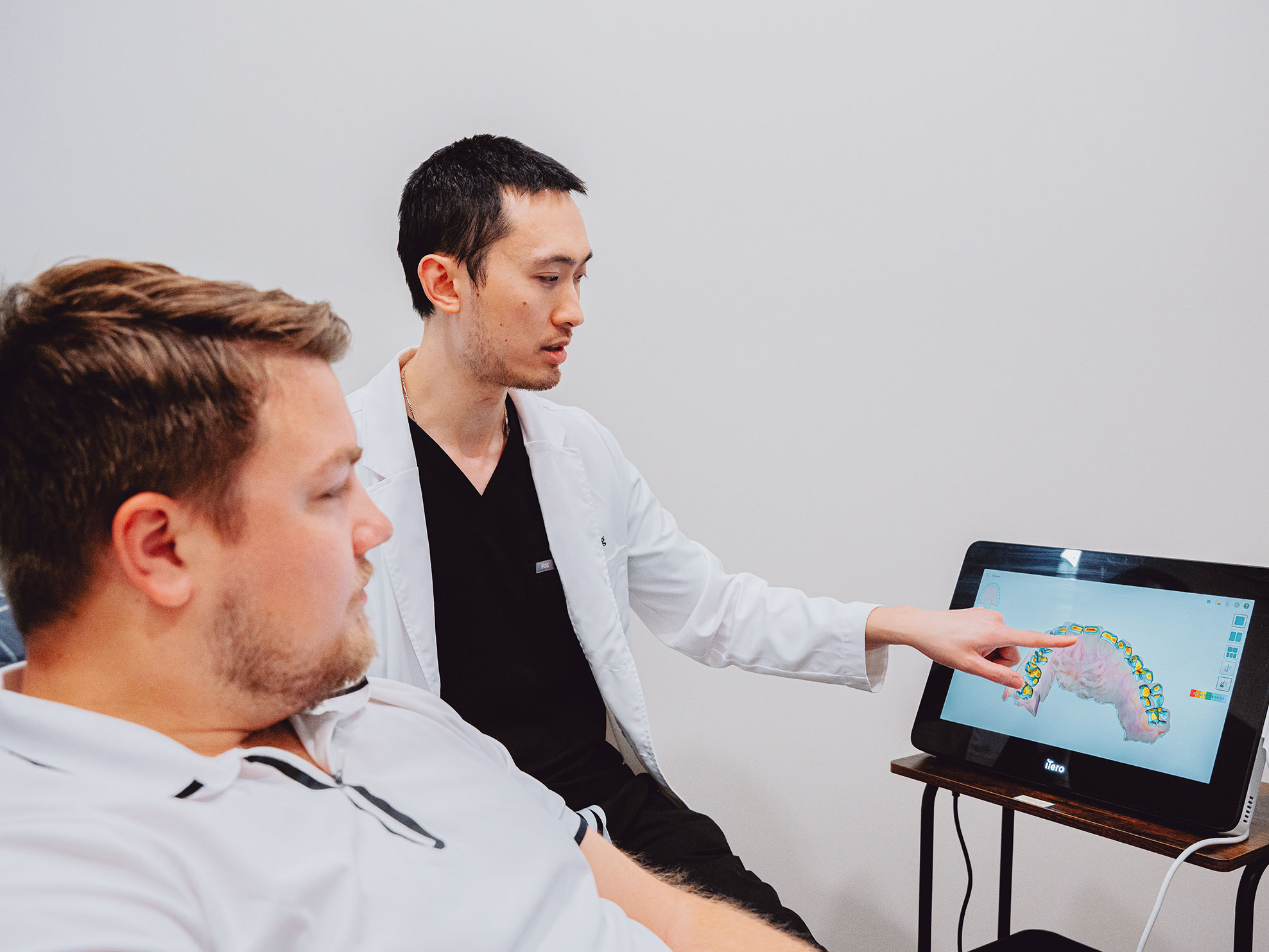 Dentist showing dental scan on screen to patient at Hometown Smiles Dentistry in League City, TX